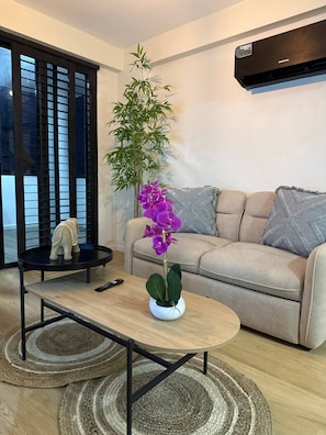 Una sala moderna con un sofá, una mesa de centro, una planta en maceta y una figurita decorativa de elefante.