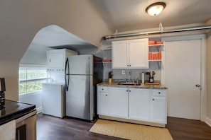 A compact kitchen with a refrigerator, stove, and sink.
