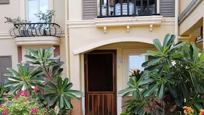 A two-story building with a stone pathway leading to a wooden door. - Noah Bed&Breakfast 3 privateStandard Room Shared Bathroom•14 mins to PPS Airport (Puerto Princesa City)