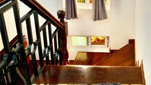 A staircase with wooden railings and a window with curtains. - Noah Bed&Breakfast 3 privateStandard Room Shared Bathroom•14 mins to PPS Airport (Puerto Princesa City)
