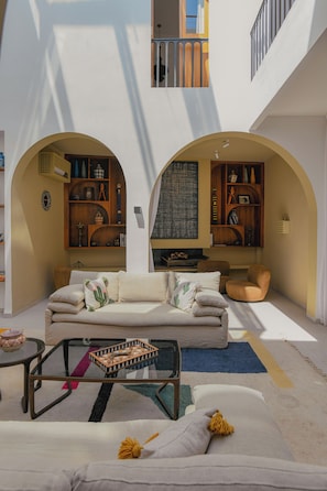 A spacious living area with a sofa, coffee table, and decorative items. - Asilah (Marrakech)