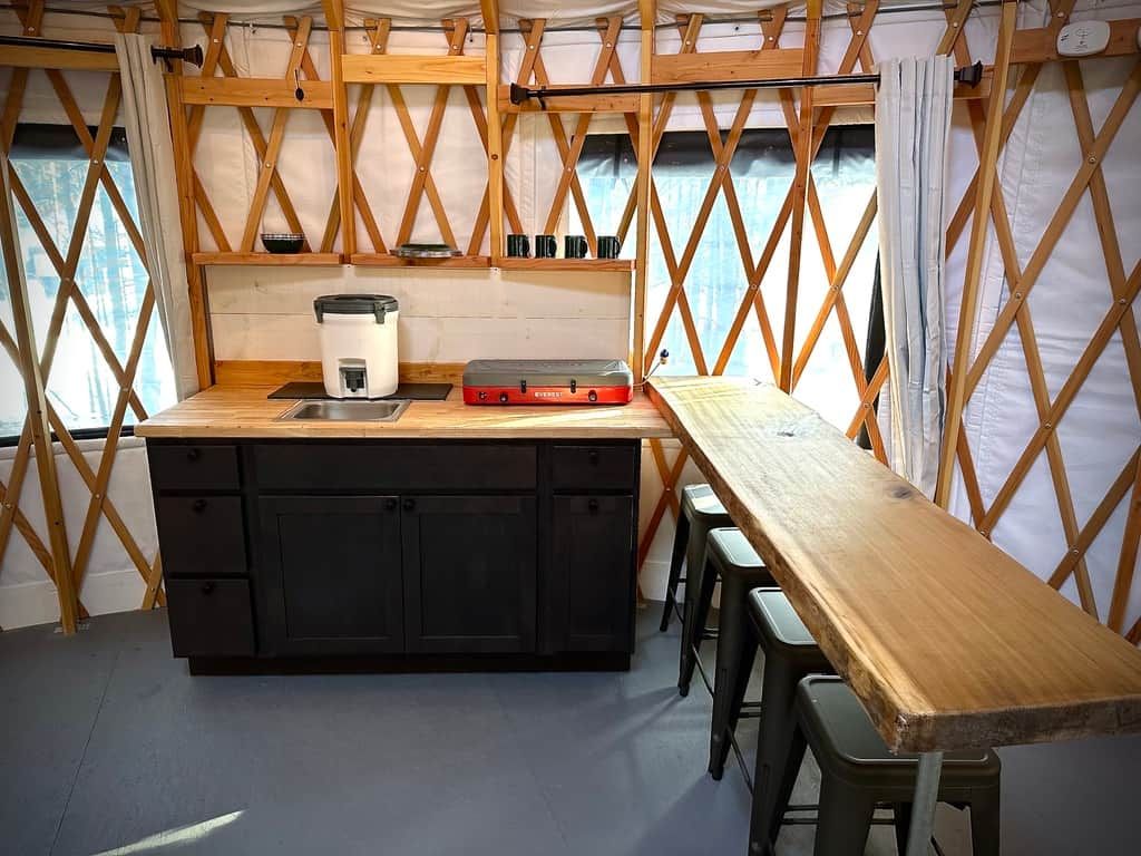 Een kleine keuken met een houten aanrecht, een spoelbak en een koffiezetapparaat.
