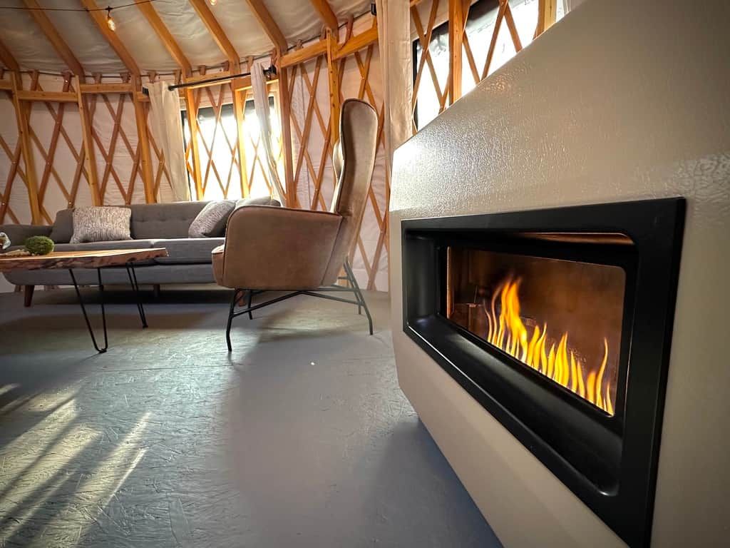 A cozy room with a fireplace, a sofa, and a chair.
