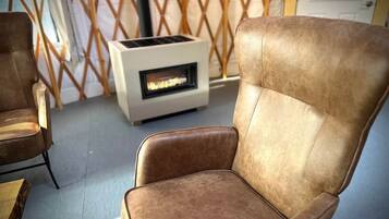 A room with a brown leather chair, a white heater, and a wooden lattice partition.