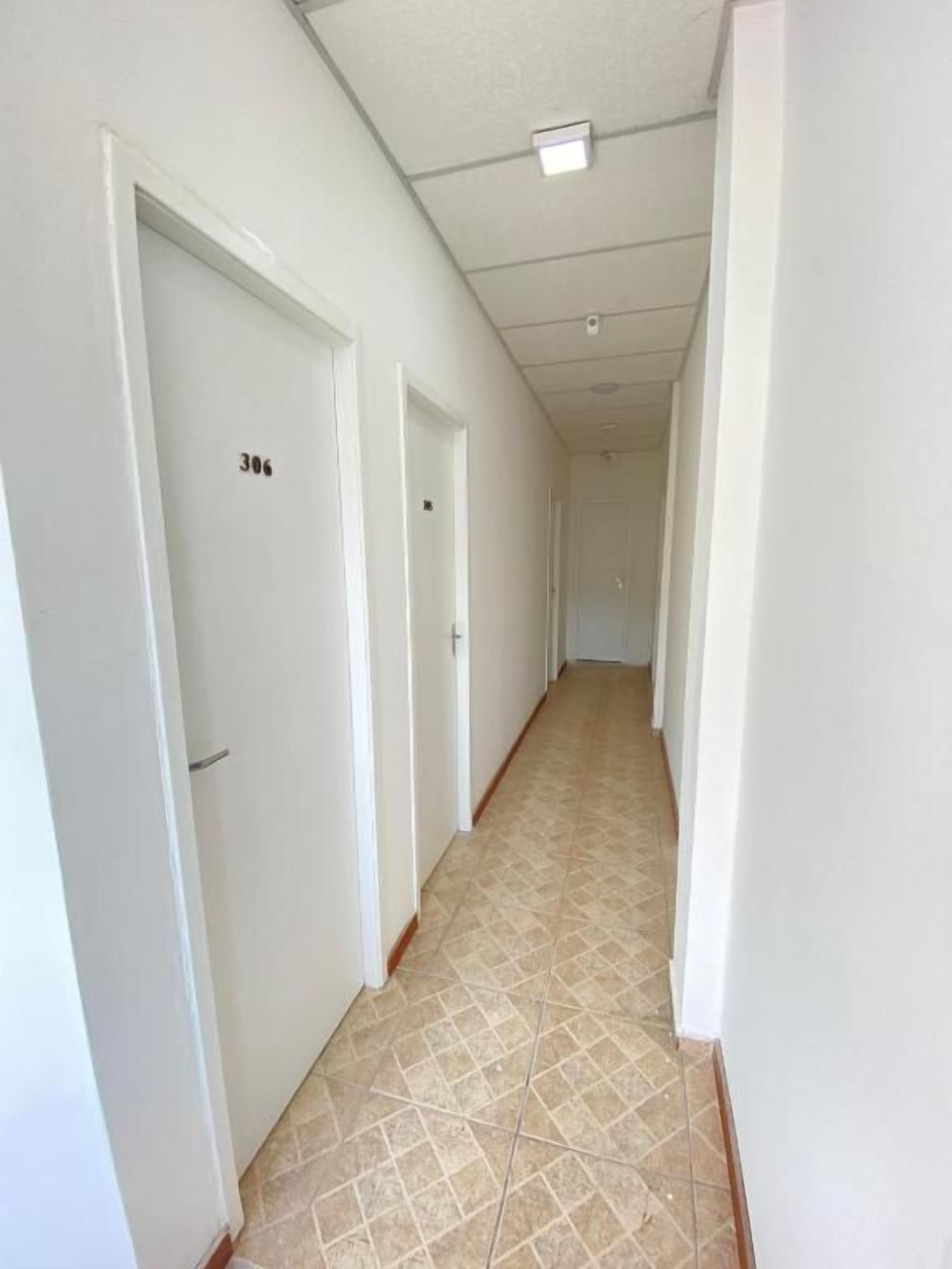 A corridor with white doors, each marked with a number.