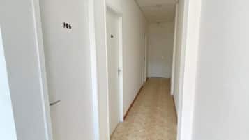 Un pasillo con puertas blancas, cada una numerada.
