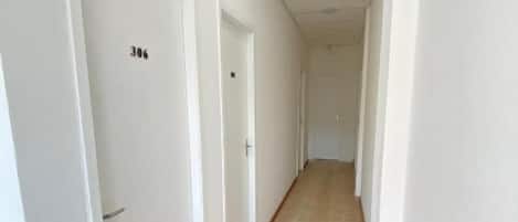 Un pasillo con puertas blancas, cada una numerada.