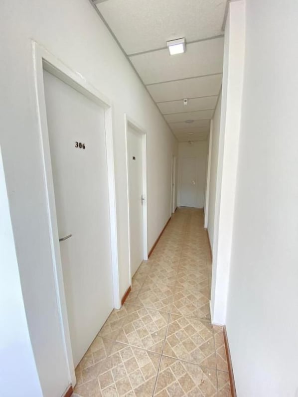 A corridor with white doors, each marked with a number.