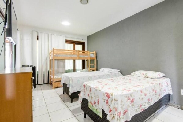 Una habitación con literas, un escritorio y una ventana con cortinas.