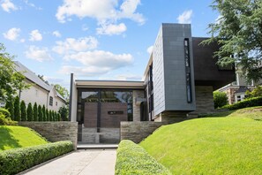 A modern two-story house with a stone facade and a flat roof. - Amani Manor (Atlanta)