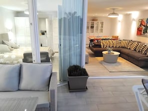 A modern living room with a sofa, a coffee table, and a dining area with chairs and a table. - Boutique Atalaya Sea View (NEW, 34 five-star reviews on a well-known partner website) (COSTA ADEJE)