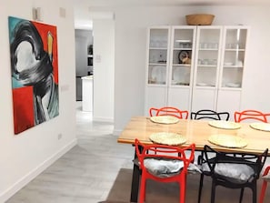 A dining area with a wooden table, red and black chairs, and a white cabinet with glass doors. - Boutique Atalaya Sea View (NEW, 34 five-star reviews on a well-known partner website) (COSTA ADEJE)