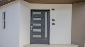 Eine moderne Tür mit Schlüsselloch und einem kleinen Fenster darüber.