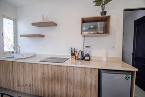 Una cucina moderna con mobili in legno, forno a microonde integrato, macchina da caffè e lavastoviglie.