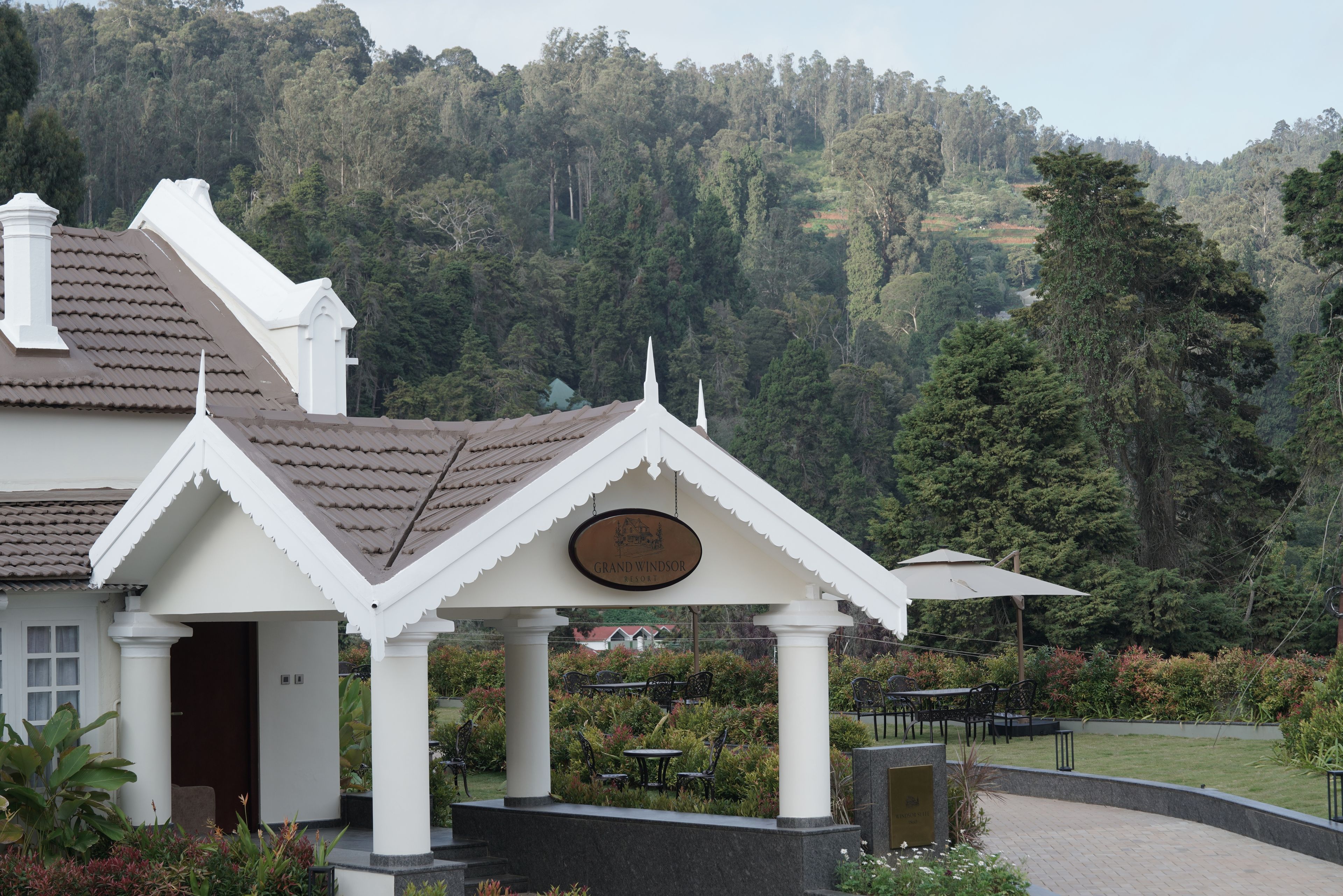 A building with a white facade, a tiled roof, and a sign indicating 'Grand Windsor Resort.'