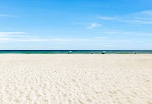 A wide sandy beach with a clear blue sky. - Villas on the Gulf A4 | Steps to Beach | Pool (Gulf Breeze)