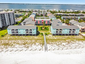 A coastal hotel with multiple-story buildings, a central courtyard, and a beach access walkway. - Villas on the Gulf A4 | Steps to Beach | Pool (Gulf Breeze)