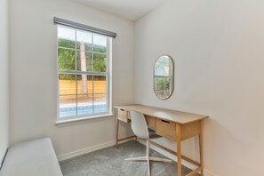 A room with a desk, chair, window, and a mirror. - Private Pool Game Room 8 Min to Perdido Key (Pensacola)