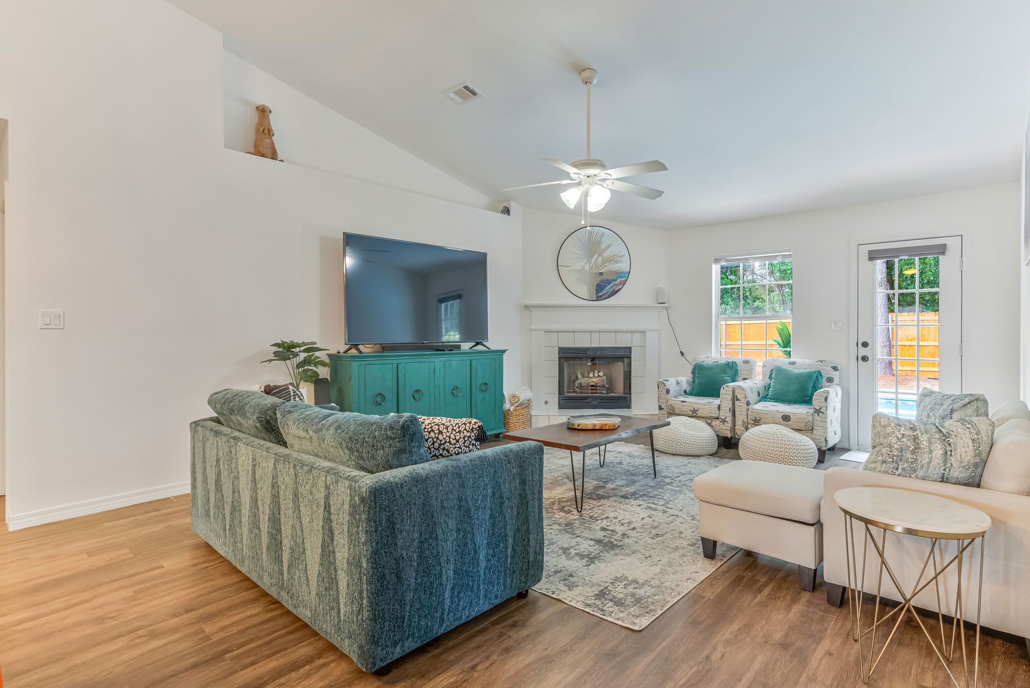 A modern living room with a sofa, armchairs, a coffee table, and a fireplace.