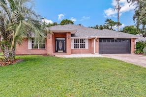 A single-story house with a brick facade, a black front door, and a garage. - Private Pool Game Room 8 Min to Perdido Key (Pensacola)