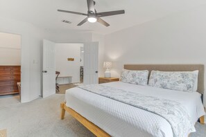 A bedroom with a bed, a ceiling fan, and a nightstand with a lamp. - Private Pool Game Room 8 Min to Perdido Key (Pensacola)