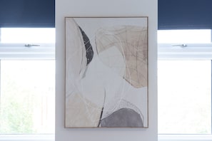 Ein gerahmtes abstraktes Gemälde an einer Wand.