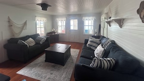 Ein Wohnzimmer mit zwei Sofas, einem Couchtisch und einer Tür mit der Aufschrift 'Harbor Island'.