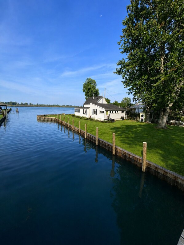 Una casa junto a un lago tranquilo con un muelle de madera que se adentra en el agua.