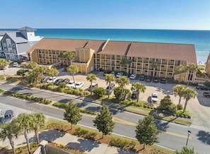 A hotel with a parking lot, a road, and a view of the ocean. - Coral Reef Ground level unit 10 Epic Views! (Destin)