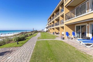 Ein Hotel mit Poolbereich, Liegestühlen und Blick auf den Strand.