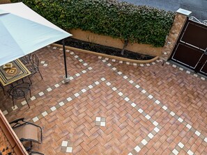 A patio area with a tiled floor, a table with chairs, and a potted plant. - Family Sicilian Heritage Home (Trecastagni)