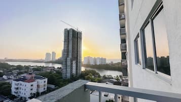 Un rascacielos con una grúa de construcción, rodeado de otros edificios y un río.