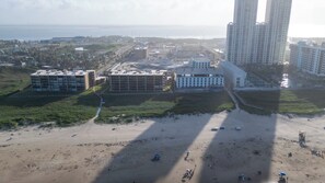 An aerial view of a coastal area with buildings, a beach, and a body of water. - Gulfview - 250 yrds to Beach Bbq Poolside (South Padre Island)