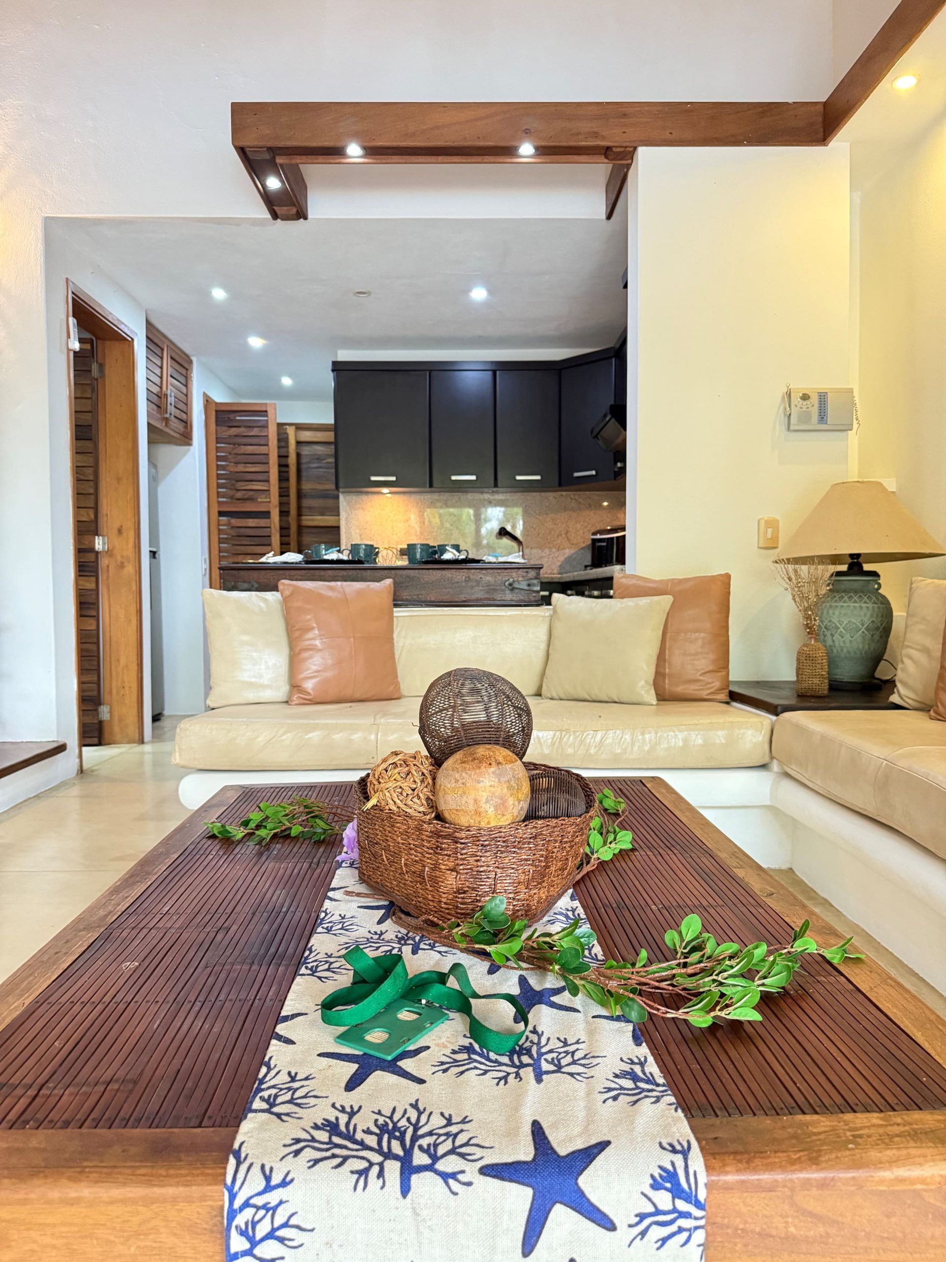 Una sala de estar con un sofá, una mesa de centro con una cesta de mimbre y una lámpara.