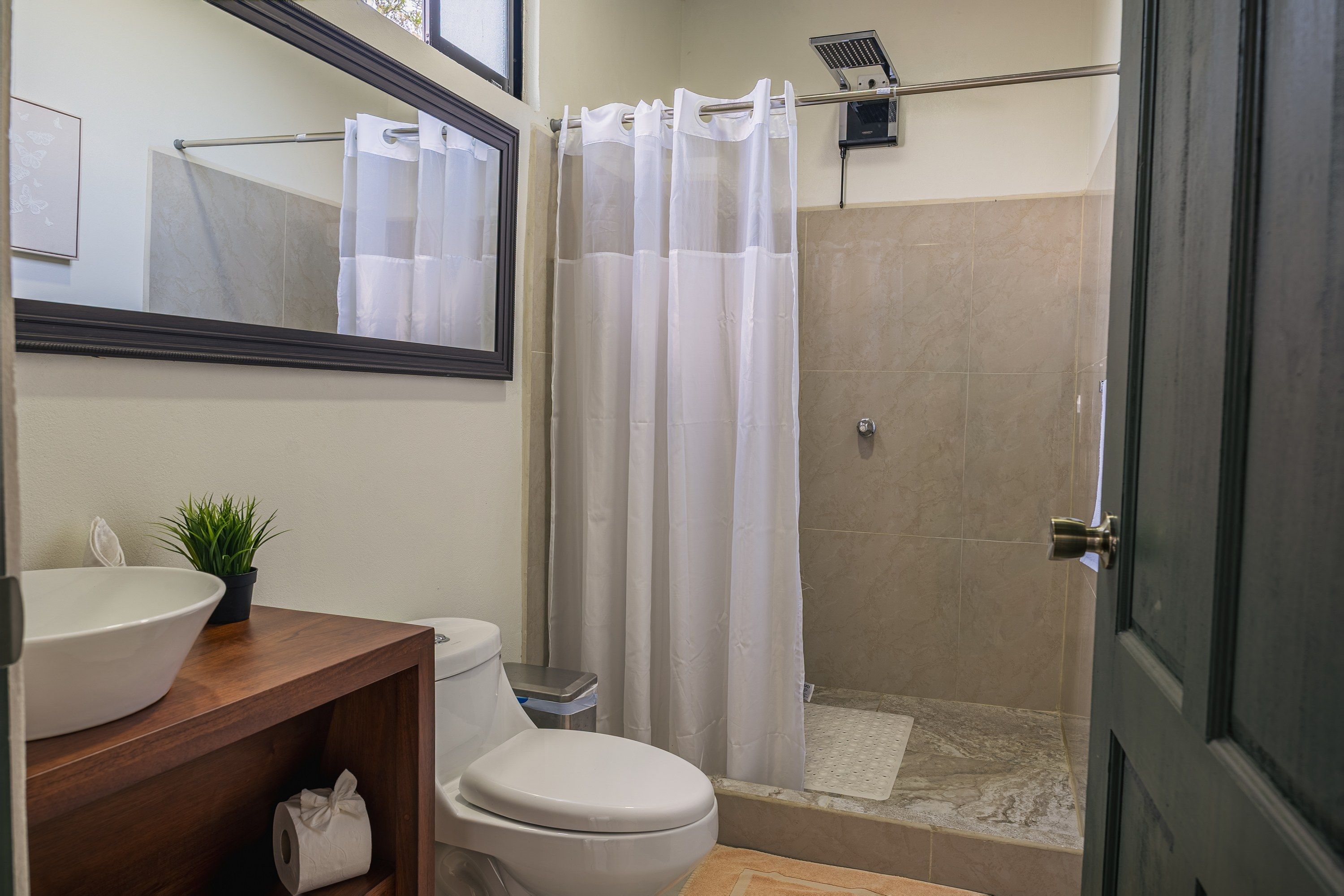 A bathroom with a toilet, sink, and shower area.
