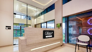 A reception desk with a sign indicating it is serviced by OYO. - Saver Double Hotel Nano Pod (Surat)