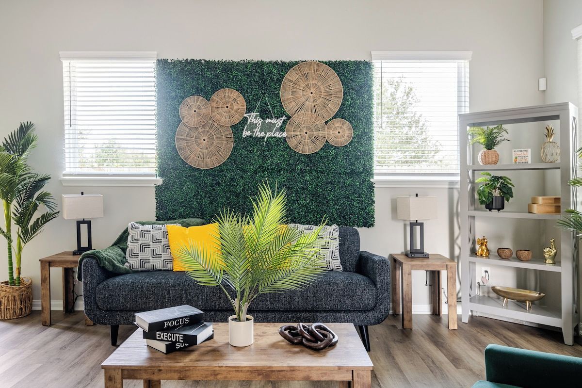A living room with a green wall, a sofa, a coffee table, and a bookshelf.