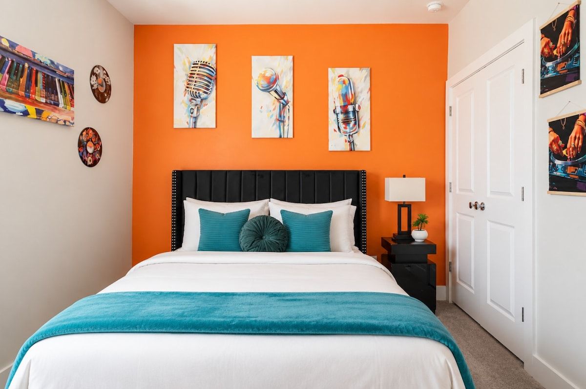 A hotel room with a bed, a nightstand, and a door.