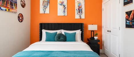 A hotel room with a bed, a nightstand, and a door.