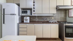 Eine kleine Küche mit Kühlschrank, Mikrowelle, Toaster, Gasherd und Backofen.
