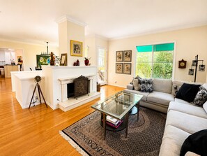 A living room with a fireplace, a sofa, a coffee table, and a rug. - Beautiful Home in Quiet Gated Community Near Hendry's Beach-3Bedrooms 2.5 Baths (Santa Barbara)