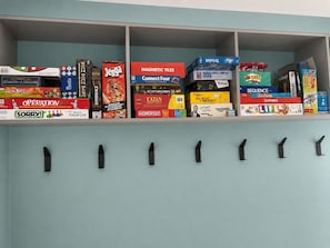A shelf with various board games and a magnetic board game.