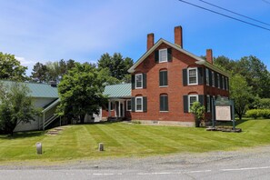 A large brick building with a green roof, a covered porch, and a sign indicating it is a spa.