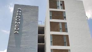Un edificio a più piani con un cartello verticale ben visibile che riporta 'ANDROMEDA'.