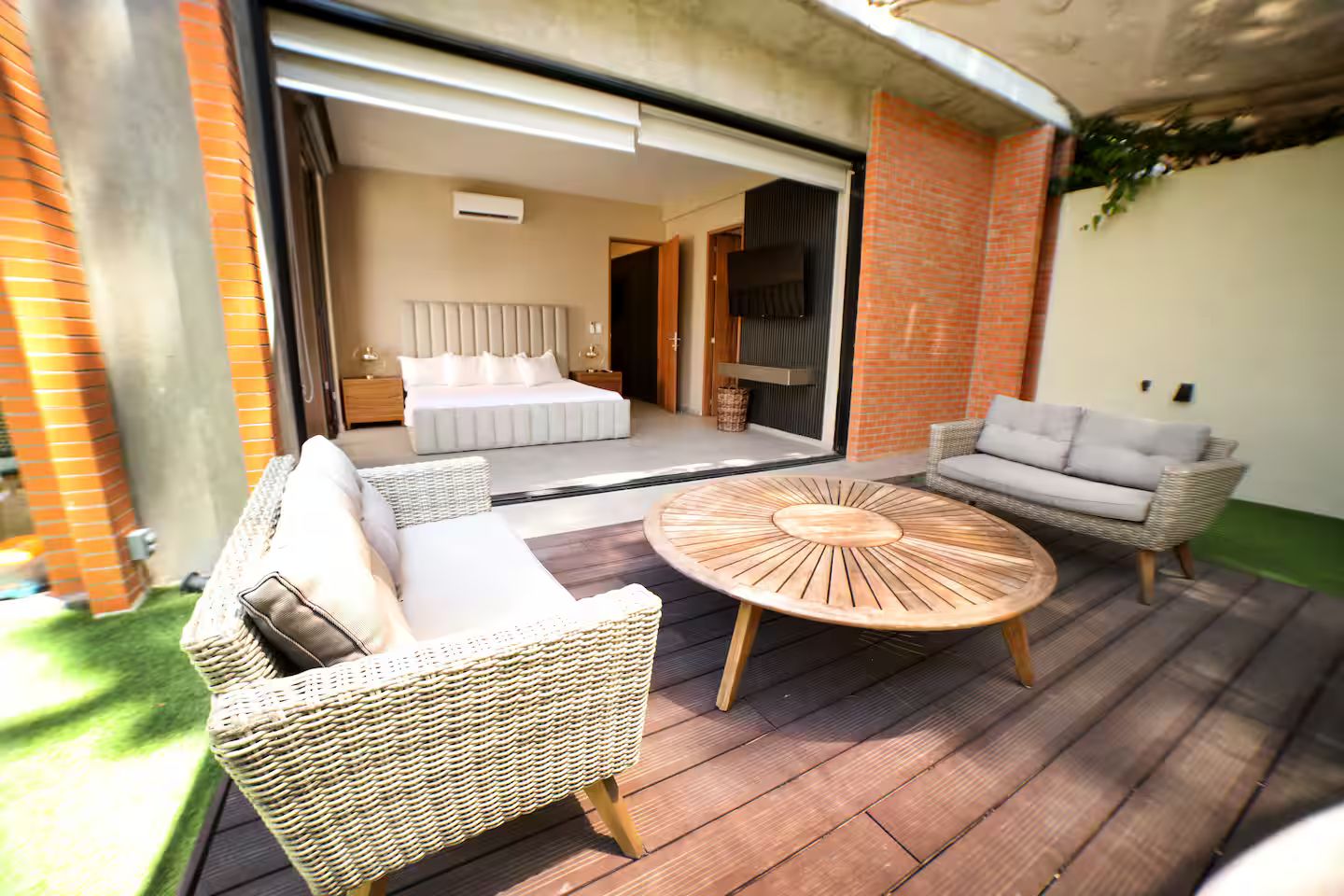 A patio with wicker furniture, a round wooden table, and a sofa.