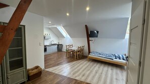 Un espacio habitable compacto con un dormitorio en entrepiso, comedor y cocina.