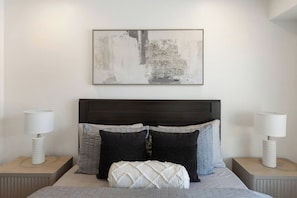 A bedroom with a dark headboard, a large abstract painting, and two bedside lamps. - Pool, PickleBall, xBox, Dog Friendly close to Zion National Park (Washington)