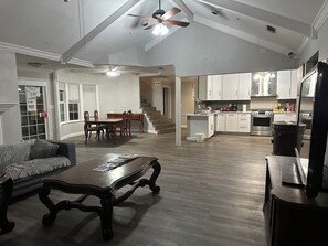 A spacious living area with a dining table, a sofa, and a kitchen with white cabinets and appliances. - Private Room in a Spacious, Budget-Friendly Home (Keller)