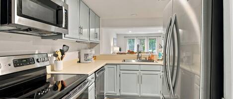 A modern kitchen with stainless steel appliances, a built-in oven, and a microwave.