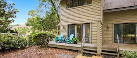 Azure chairs pop against the timber siding of this quiet back deck, where mossy oaks offer a cooling canopy. Afternoon glow filters through the leaves, creating a peaceful spot to breathe in the forest air from your private outdoor escape.